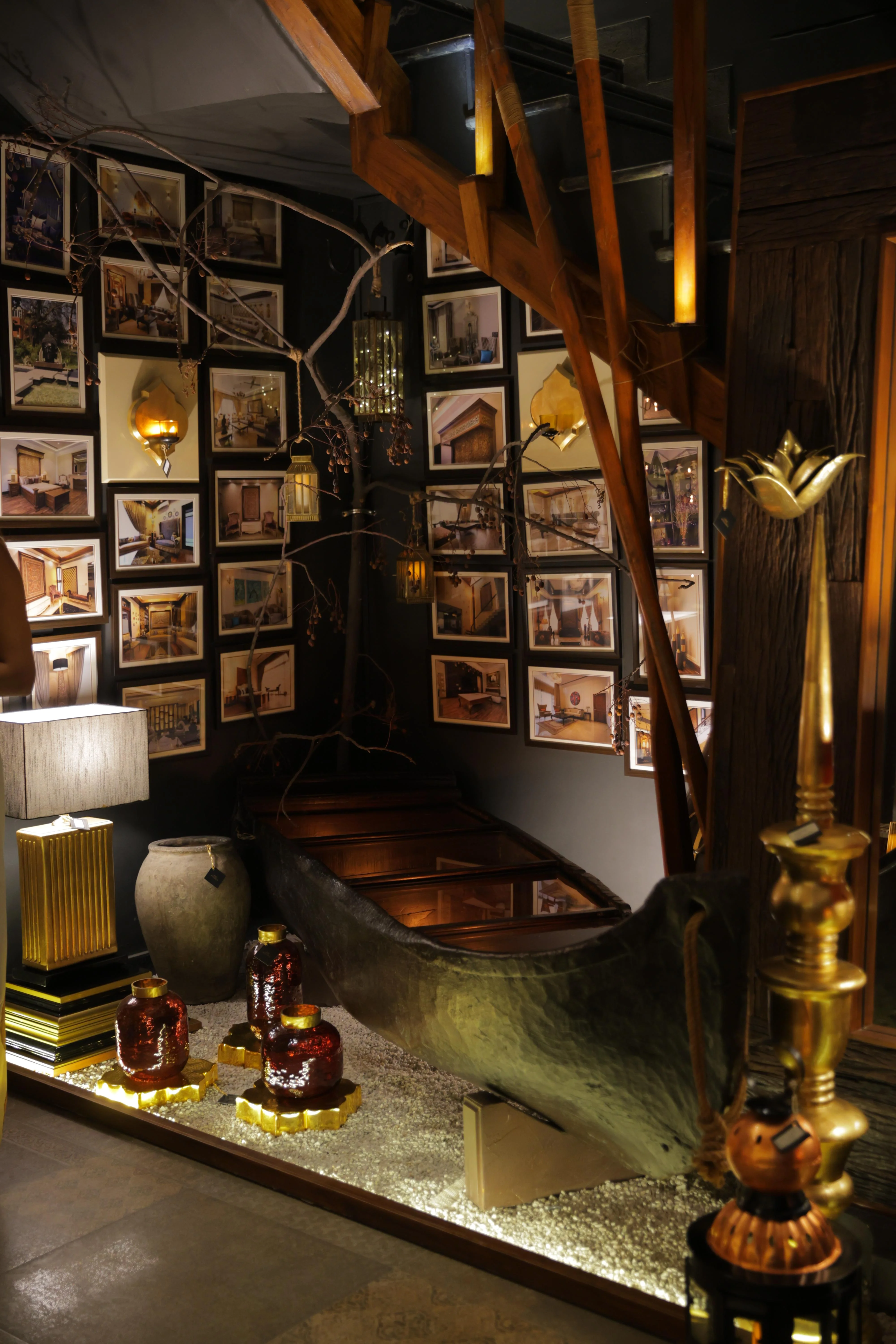 Gallery interior view with warm lighting, framed artwork on walls, and decorative lamp